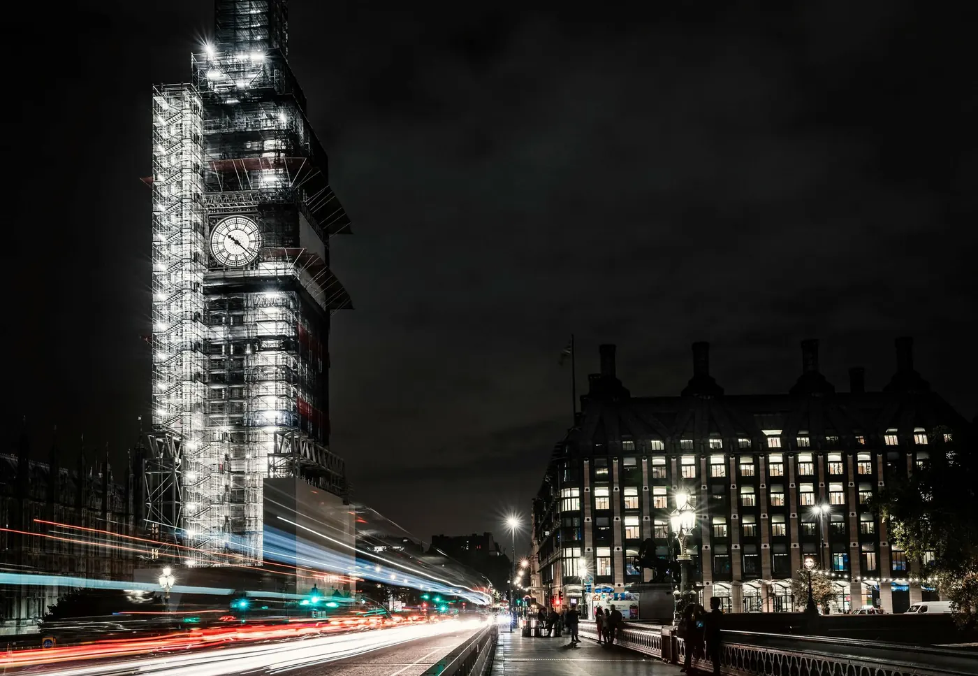 The Elizabeth Tower in scaffolding at night, with traffic on Westminster Bridge